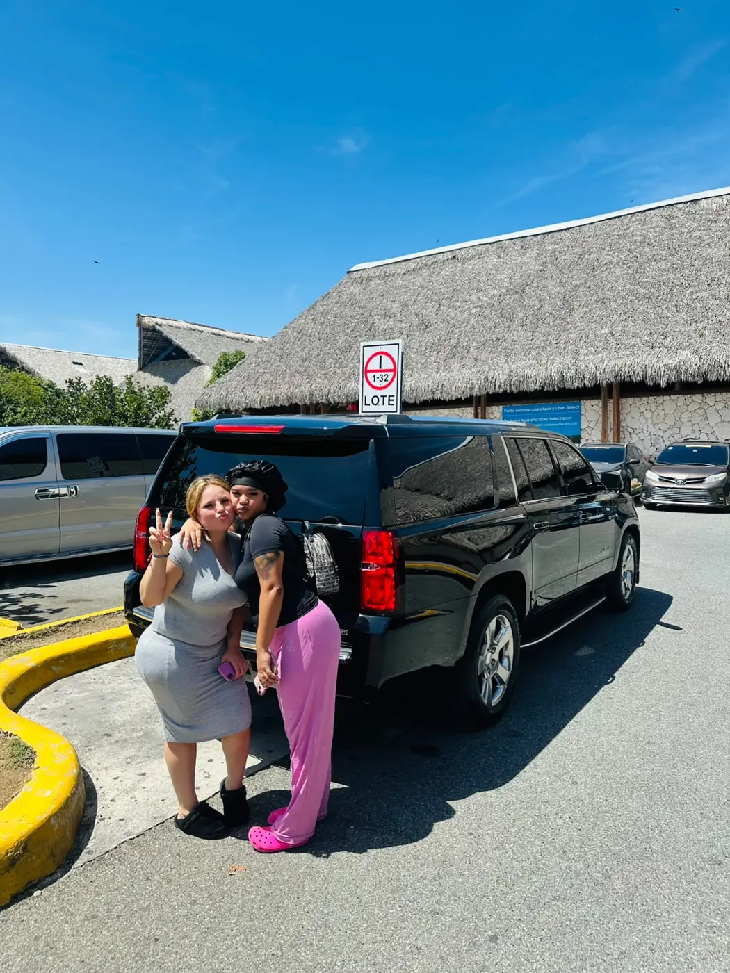 Two friends next to their private SUV at the Punta Cana Airport parking area